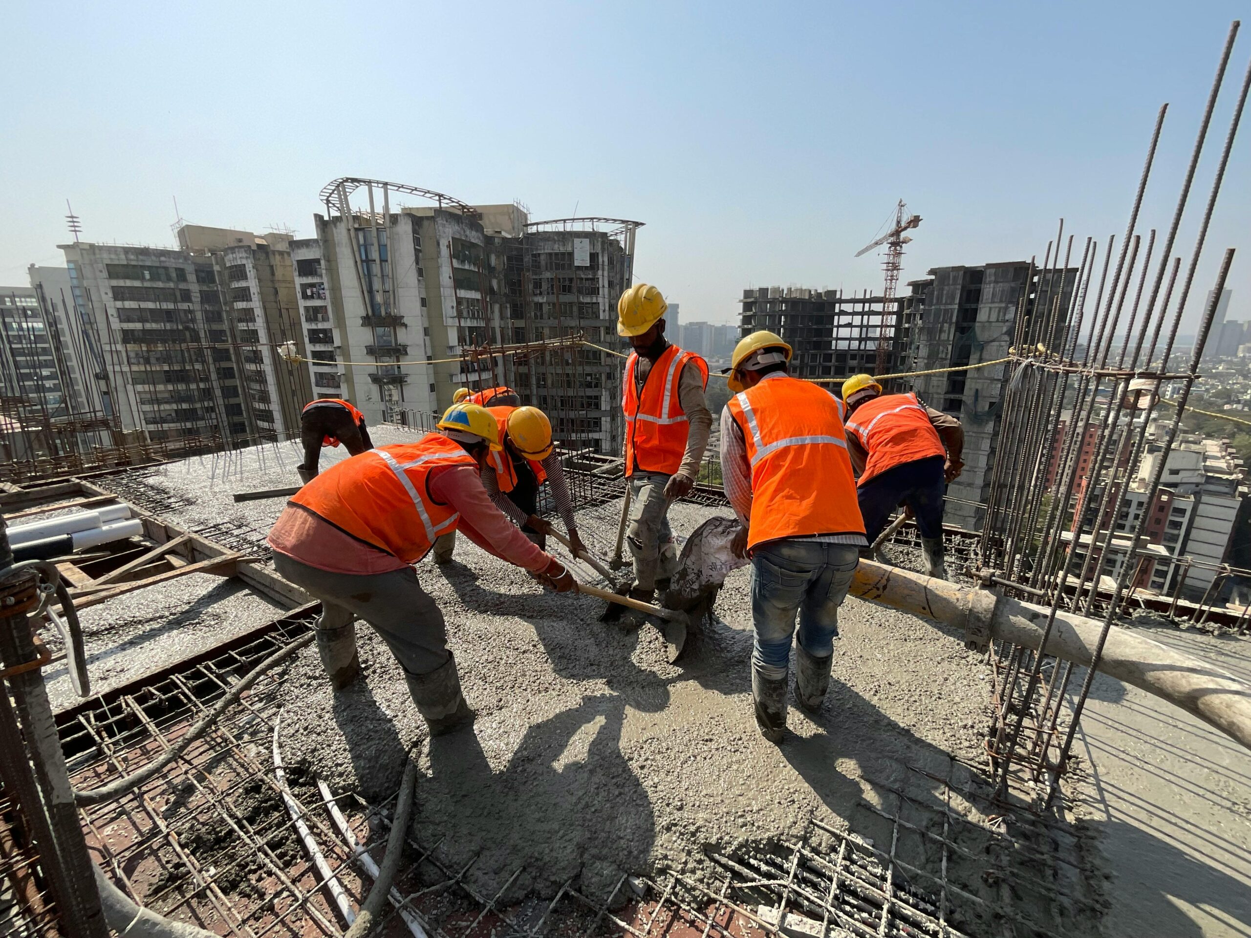 Construction workers pouring concrete on a high-rise building in Mumbai, India.